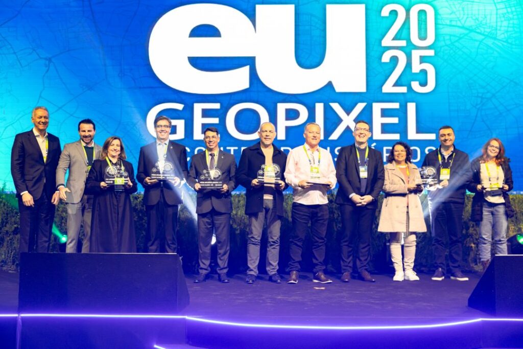 Equipe Geopixel recebendo prêmio de reconhecimento como autoridade em geointeligência municipal no evento eu 2025, com representantes no palco segurando troféus que celebram a liderança da empresa no fornecimento de soluções tecnológicas para gestão pública. Equipe Geopixel recebendo prêmio de reconhecimento como autoridade em geointeligência municipal no evento eu 2025, com representantes no palco segurando troféus que celebram a liderança da empresa no fornecimento de soluções tecnológicas para gestão pública.